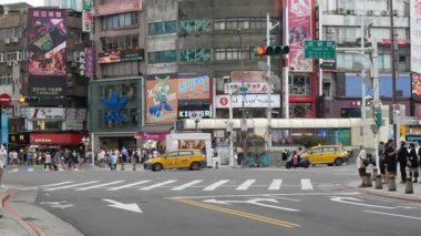 July26,2023.Taipei,Taiwan.street road view in the city of Taipei with people pedestrian crossing street road and many cars traffic in day time at Ximending famous tourist desination shopping area
