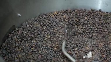Yakından seçici odaklı aromatik kavrulmuş kahverengi kahve çekirdekleri kavrulduktan sonra özel soğutucuda dönüyor, Kahve kızartma makinası taze kavrulmuş kahve çekirdeklerini soğutuyor.