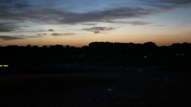 24 Temmuz 2023. Cingapore Changi Uluslararası Havaalanı. Yazın gün batımında gökyüzü ile birlikte Changi Havalimanı 'nda faaliyet gösteren uçak uçağıyla birlikte havaalanı manzarası.