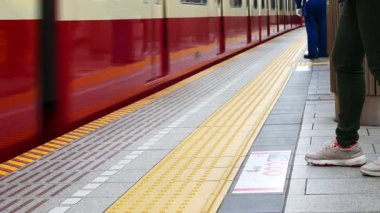 Tokyo metro istasyonunun düşük açılı görüntüsü. İnsanlar Tokyo metrosu ulaşım istasyonuna yaklaşmayı beklerken.