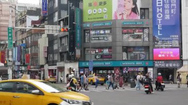 July26,2023.Taipei,Taiwan.street road view in the city of Taipei with people pedestrian crossing street road and many cars traffic in day time at Ximending famous tourist desination shopping area