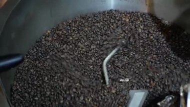 Yakından seçici odaklı aromatik kavrulmuş kahverengi kahve çekirdekleri kavrulduktan sonra özel soğutucuda dönüyor, Kahve kızartma makinası taze kavrulmuş kahve çekirdeklerini soğutuyor.