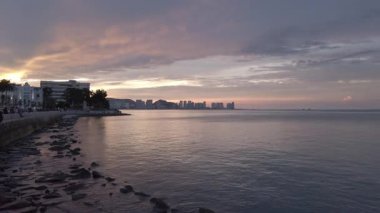 Penang Körfezi ve Penang Modern Şehrinin arka planında sahil kenarındaki Bayfront Parkı. Yaz tatilinde bulutlu günbatımı gökyüzü. Penang Körfezi Sahil Sahil Sahil Bölgesi