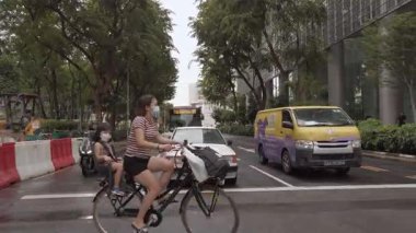 23 Ağustos 2022. Cadde kavşağında yürürken insanların yaz güneşinde caddeyi geçerken, Singapur şehir trafiği caddesi şehir merkezinde.