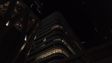 Şehir merkezindeki modern ofis binalarına bakıyorum. Şehir merkezindeki finans binalarına bakıyorum. Gökyüzü saatine kadar olan modern cam binalara bakıyorum.