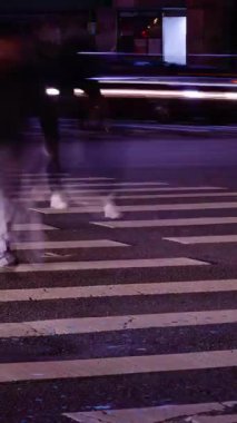 dikey zaman kavramı düşük açı görüntüsü kavşaktaki asfalt cadde kavşağına gece vakti kalabalık yaya kalabalığı caddeyi geçerken ve trafik saatlerinde biraz araba trafiği