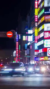 29 Temmuz 2023 Taipei, Tayvan. Gece dikey zaman çizelgesi sokak manzarası sokak trafiği ve renkli reklam panosu olan bina.