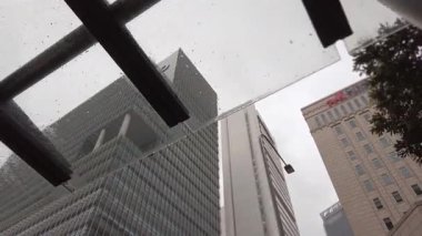 Şehir ticaret bölgesindeki modern ofis, gökdelen ve finans binalarına bakıyorum. Gökyüzüne kadar uzanan, arka planda berrak gökyüzü olan modern cam binalara bakıyorum.