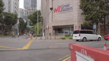 23 Ağustos 2022. Cadde kavşağında yürürken insanların yaz güneşinde caddeyi geçerken, Singapur şehir trafiği caddesi şehir merkezinde.