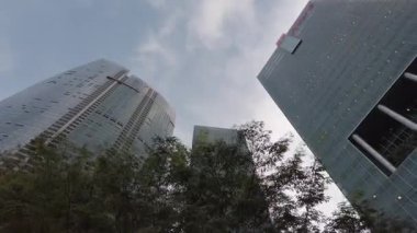 Şehir ticaret bölgesindeki modern ofis gökdelenleri finans binaları. Arka planda açık gökyüzü ile gökyüzüne yükselen modern cam binalara bakarken yukarı bakıyorum.