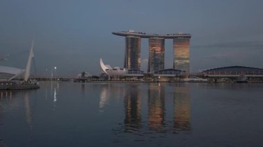Günbatımında Singapur 'un merkezi iş bölgesinde gökdelenler inşa eden gökdelenlerle marina körfezi su bölgesi manzarası. Gökdelen binası ile gökdelen şehri gökdeleni.