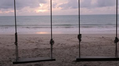 Tayland 'da hindistan cevizi ağacıyla beyaz kumsalın yanında sallanırken güneşli yaz havası ile günbatımında vanilya gökyüzü zamanı, deniz kıyısı manzarası