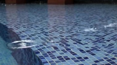 Yağmur damlacıkları bir yüzme havuzunun yüzeyine düşer, yağmur damlasını kapatır ve havuza sıçrar. Yağmurlu hava tahmini doğa arka plan konsepti