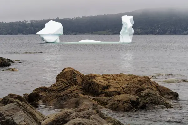 カナダのニューファンドランド ラブラドール州トウィリンゲートの漁村の海岸近くの壮大な氷山 ストック写真