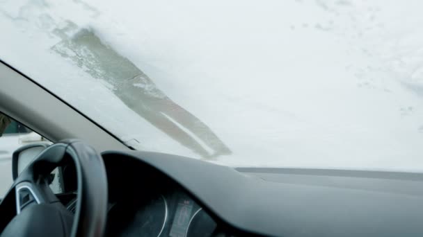 Seorang Pria Menggores Embun Beku Dari Jendela Depan Mobilnya Pagi — Stok Video