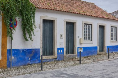 Portekiz, Lizbon 'da tek katlı bir binada beyaz çerçeveli üç gri ahşap kapı. Portekiz turu. Ekim 2023.