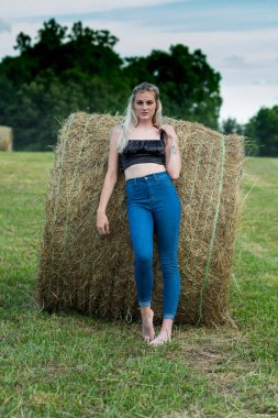 Sarışın bir çiftçinin kızı çiftlik ortamında poz veriyor.