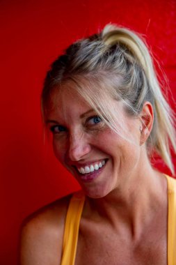 A gorgeous blonde model enjoys a day at home against a red wall before heading to work