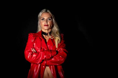 Çekici sarışın bir fetiş modeli stüdyo ortamında poz veriyor.