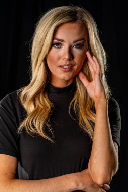 Çekici sarışın bir model stüdyo ortamında poz veriyor.