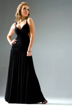 Çekici sarışın bir model stüdyo ortamında poz veriyor.