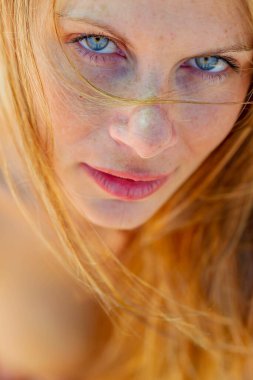 Sarışın, üstsüz bir softbol oyuncusu bahar havasının tadını çıkarırken dışarıda poz veriyor.