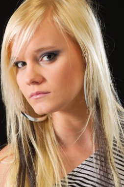 Çekici sarışın bir model stüdyo ortamında poz veriyor.