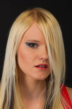 Çekici sarışın bir model stüdyo ortamında poz veriyor.