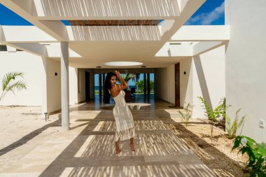 Muhteşem bir Latin model bambu tavanının altında poz veriyor, fayans zeminde güzel şekiller yapıyor..