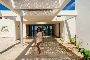 Muhteşem bir Latin model bambu tavanının altında poz veriyor, fayans zeminde güzel şekiller yapıyor..