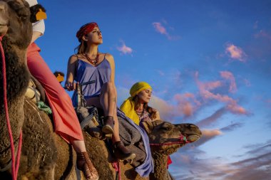 Güzel bir model Fas 'taki Sahra Çölü' nde deve sürüyor.