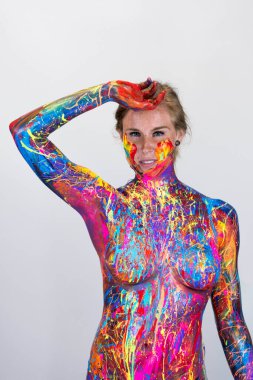 Göz kamaştırıcı bir kadın modeli, stüdyo ortamında canlı renklerle boyanır.