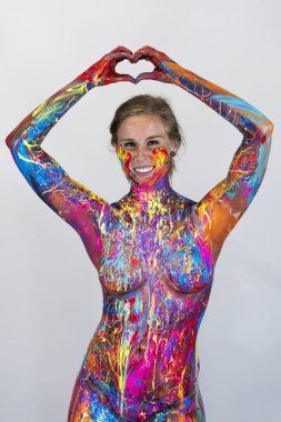 Göz kamaştırıcı bir kadın modeli, stüdyo ortamında canlı renklerle boyanır.