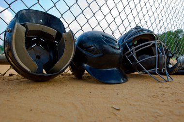 A row of batting helmets in a little league dugouts