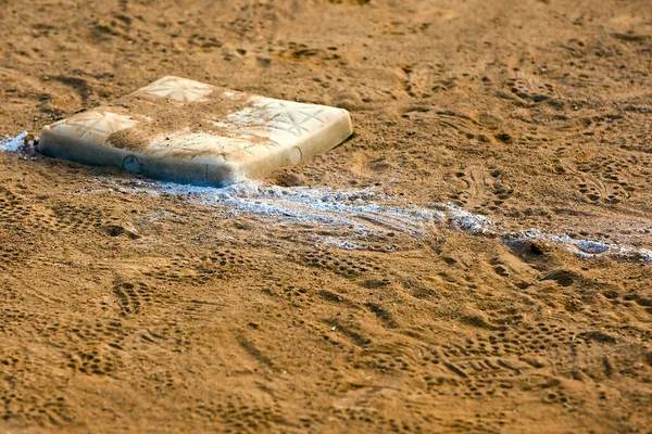 Empty base on chalked baseball field, symbol of accomplishment