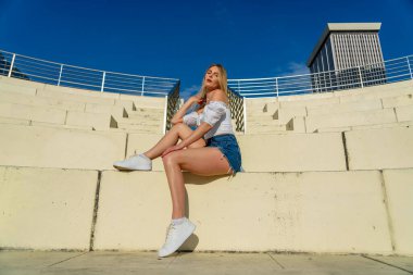 Muhteşem sarışın bir model büyük bir şehirde güzel havanın tadını çıkarıyor.