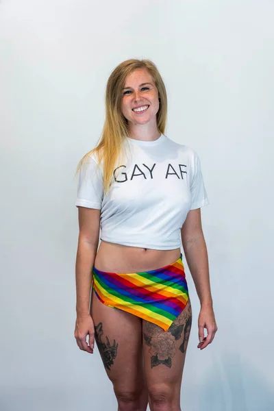 stock image Studio image of happy young blonde LBGTQ woman wearing rainbow colored clothes smiling at camera.  Concept of homophobia, diversity, equity, peace and love, freedom, liberty. LGBT rights concept.  