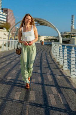 Muhteşem sarışın bir model büyük bir şehirde güzel havanın tadını çıkarıyor.