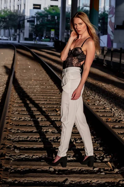 豪華なブロンドモデルは日没時に鉄道線路上にポーズ — ストック写真