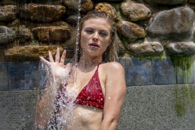 A gorgeous blonde bikini model enjoys a day at home in her swimming pool