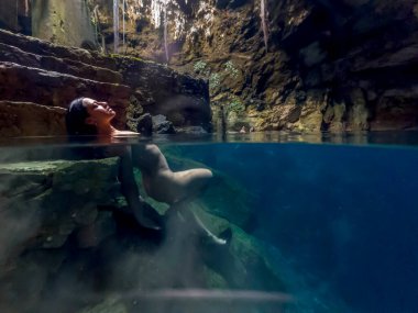 Güzel, çıplak bir Latin model, Yucatan Merida 'daki renkli mezarlıklarda muhteşem suyun tadını çıkarıyor.