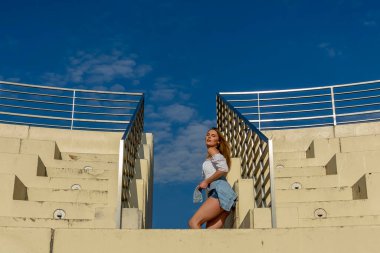 Muhteşem sarışın bir model büyük bir şehirde güzel havanın tadını çıkarıyor.