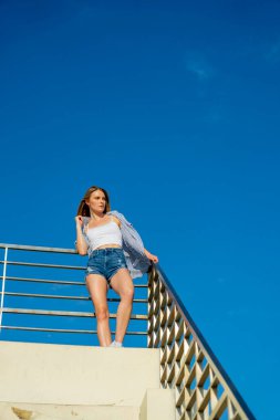 Muhteşem sarışın bir model büyük bir şehirde güzel havanın tadını çıkarıyor.