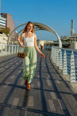Muhteşem sarışın bir model büyük bir şehirde güzel havanın tadını çıkarıyor.