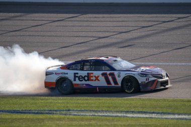 NASCAR Cup Serisi sürücüsü Denny Hamlin, Kansas City, KC, ABD 'deki Advent Health 400' de kazandığı zaferi kutluyor.