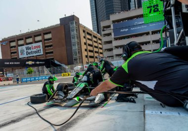 INDYCAR sürücüsü, AGUSTIN HUGO CANAPINO (R) (78) Arrecifes, Arjantin 'li, Detroit MI' deki The Streets of Detroit Grand Prix sırasında arabasını hizmet için getirir..