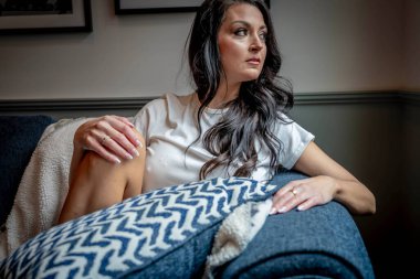 Muhteşem bir esmer model iç çamaşırlarıyla ev ortamında poz veriyor.