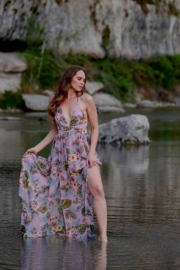 Muhteşem bir esmer model göl kenarındaki yaz havasının tadını çıkarıyor.