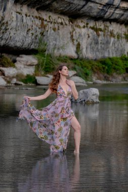 Muhteşem bir esmer model göl kenarındaki yaz havasının tadını çıkarıyor.