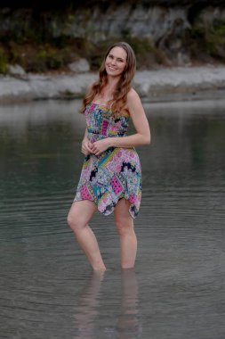 Muhteşem bir esmer model göl kenarındaki yaz havasının tadını çıkarıyor.